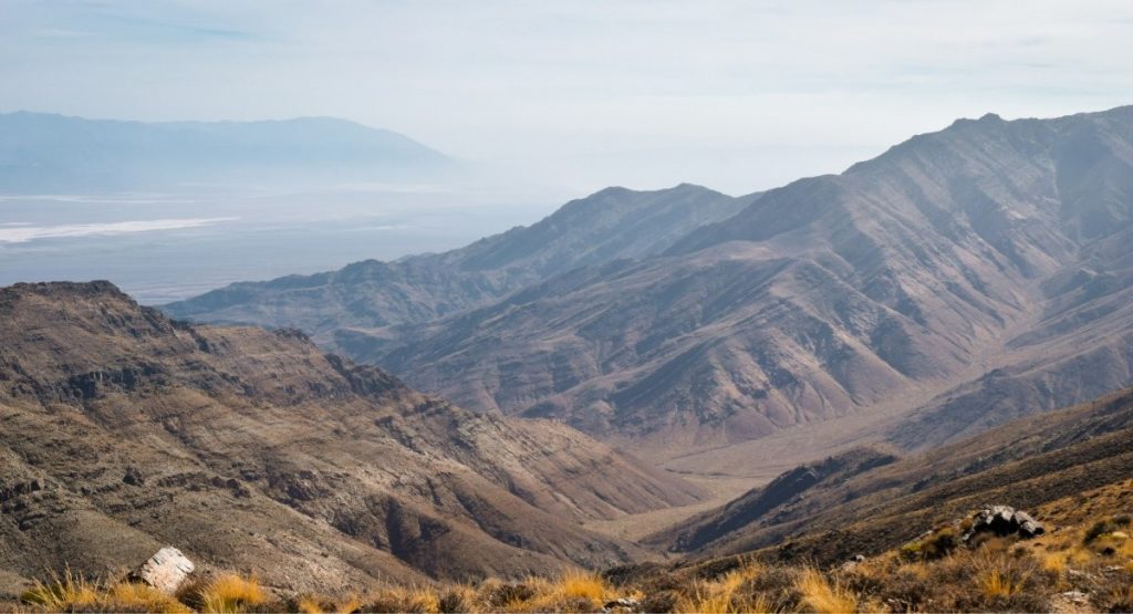 Sweeping aerial view of rugged desert mountain ridges and a dry valley